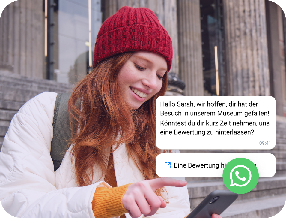 Frau mit roter Mütze liest eine WhatsApp-Business-Nachricht auf ihrem Smartphone.